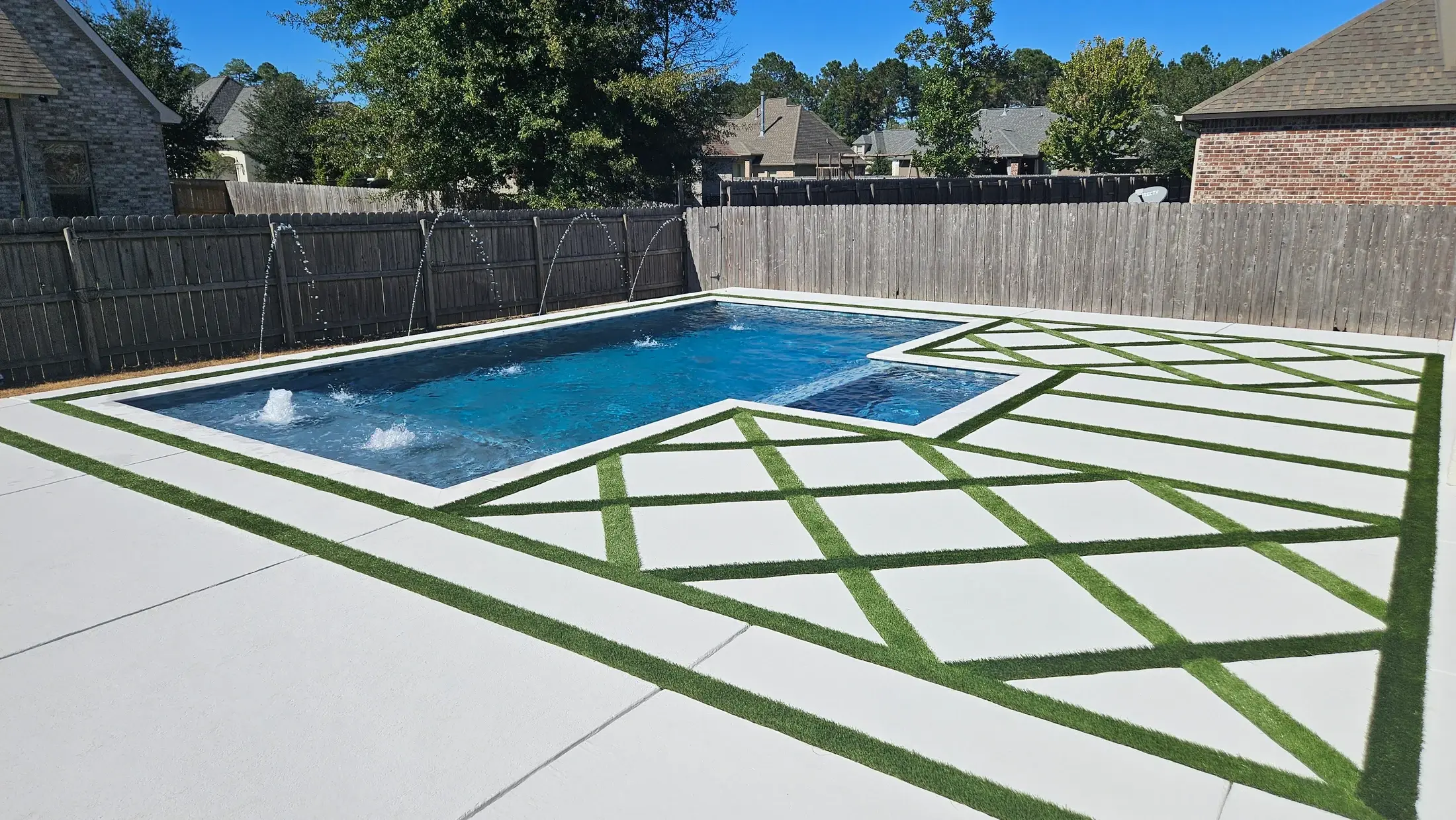 Clearwater geometric pool and spa framed by pale paving with geometric grass inlays